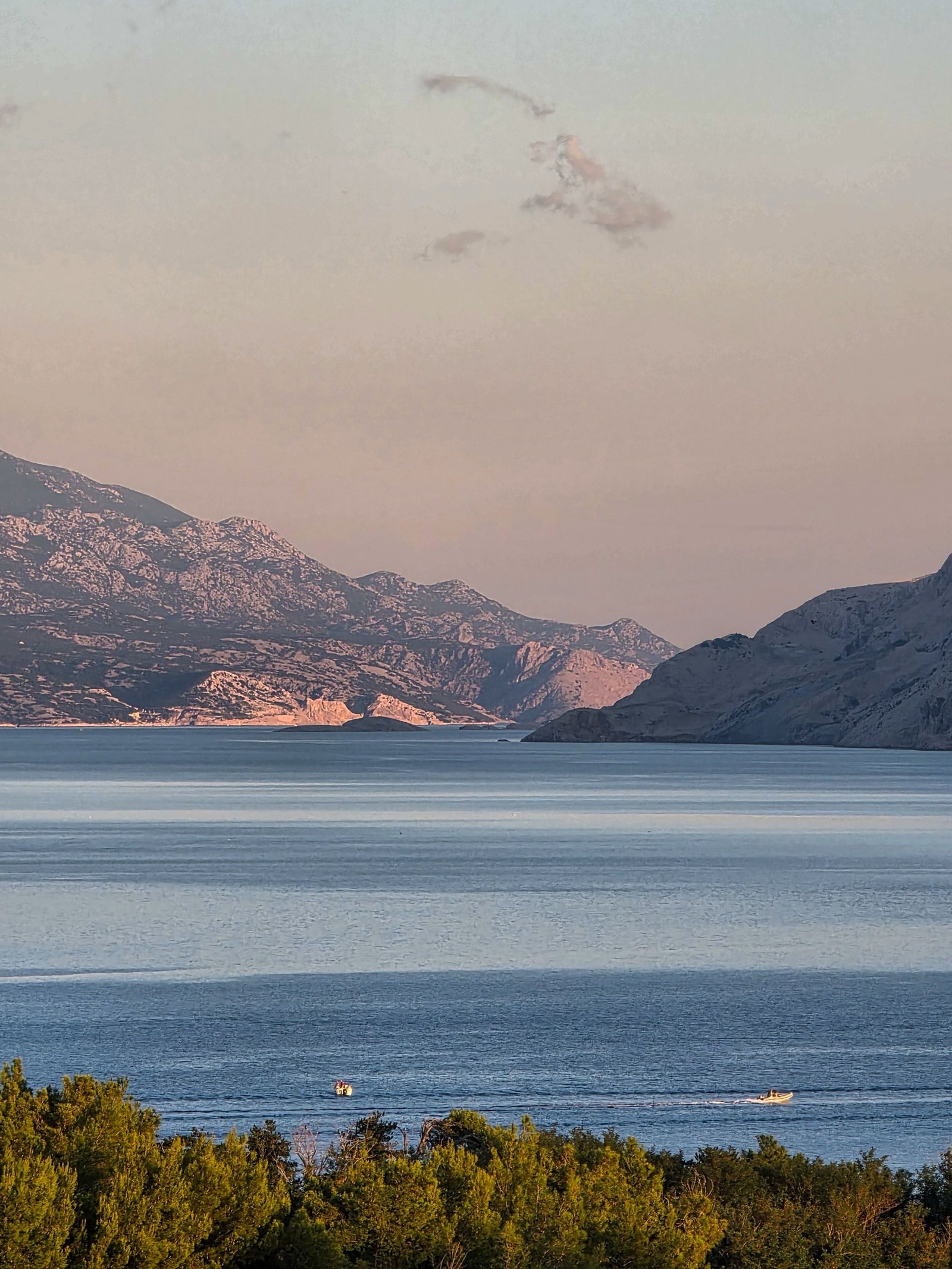 Bahía tranquila rodeada de montañas bajo la luz suave del amanecer